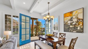 A dining area with a wooden table, chairs, and a chandelier. - Heritage 3 Bedrooms H90 by RedAwning (La Quinta)