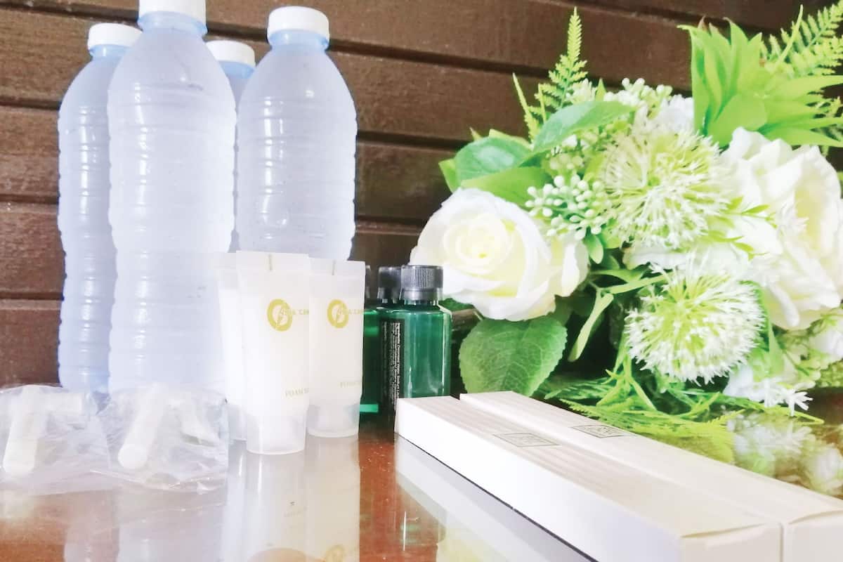 A table with plastic bottles, a white box, and a bouquet of white flowers.