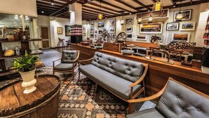 A cozy interior with a bar area, seating, and a large plant.