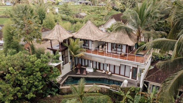 A resort with a pool, thatched-roof structures, and lush greenery. - Basundari Retreat Bali (Ubud)