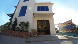 A modern two-story building with a white facade, large windows, and a welcoming entrance. - Casa Montemar B&B (Coron)