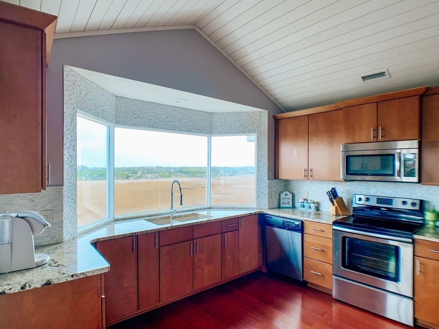 A kitchen with wooden cabinets, a stainless steel oven, a microwave, and a dishwasher.