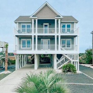 A two-story beachfront house with a balcony on each floor, a covered entryway, and a visible address number. - A Beach To Remember 4 Bedroom Home by RedAwning (Supply)