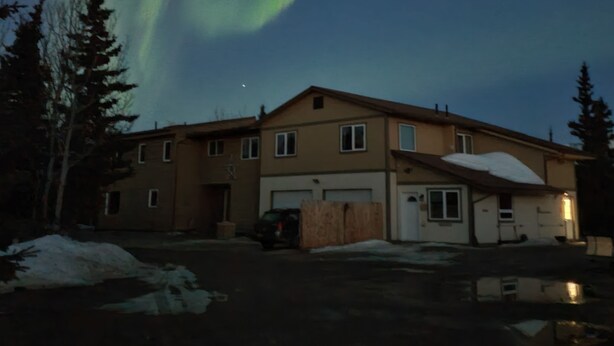 A two-story house with a garage and a covered driveway, surrounded by snow and trees. - The Taiga 2, Studio Apartment (Healy)
