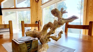 A dining area with a wooden table, chairs, and a large tree branch sculpture. - WinterPark Chalet-3br/2ba. 2decks/hottub/mtn views. Skiing/Hiking/Biking nearby. (Tabernash)