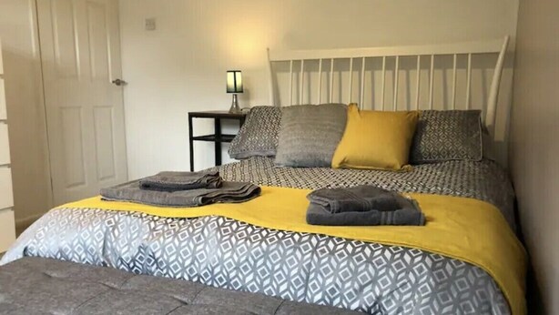 A bedroom with a bed, bedside table, and a nightstand. - Charming Village house in Bramhall near Manchester (Bramhall)