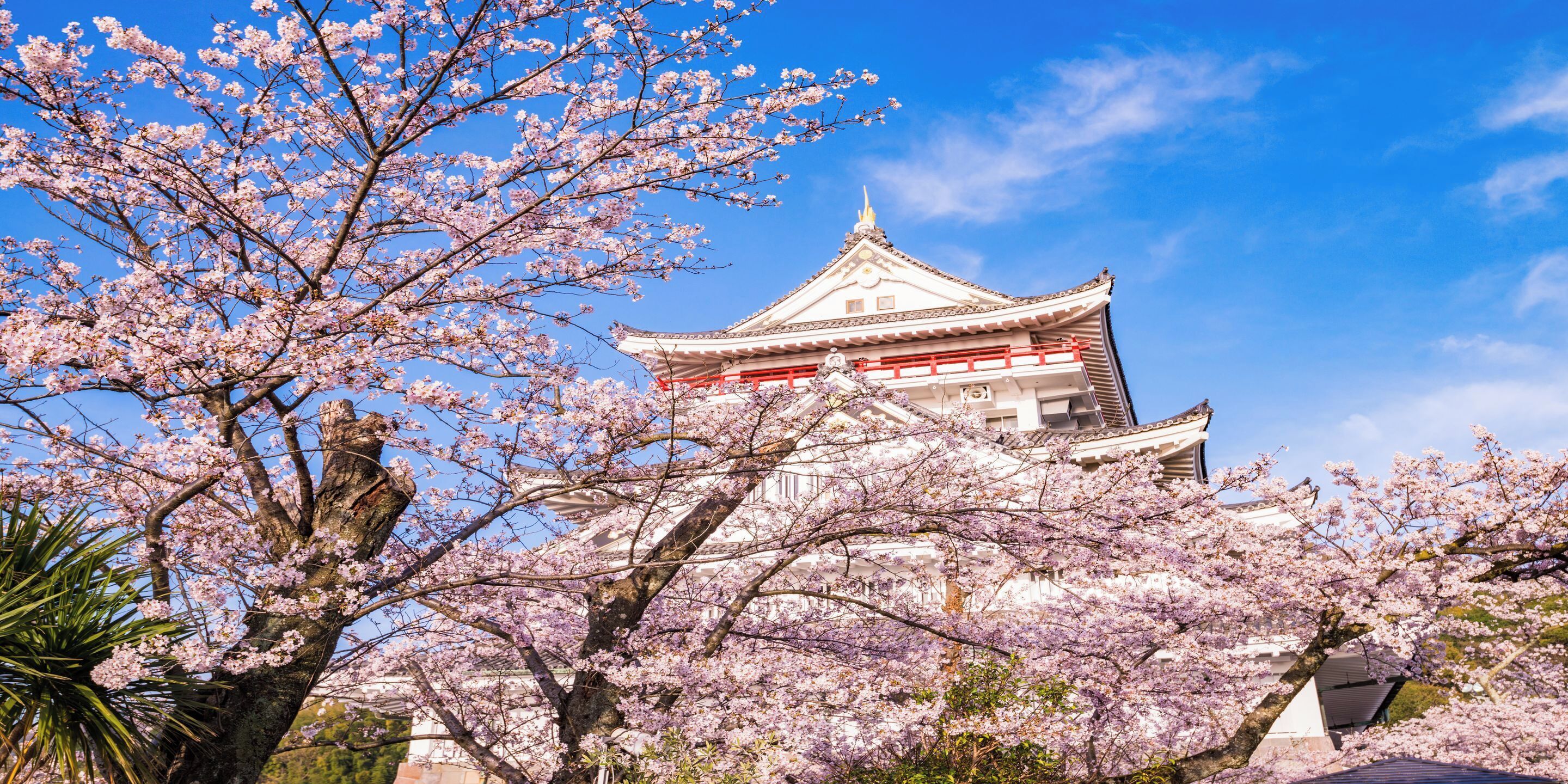 A traditional Japanese building with a multi-tiered roof and a red and white color scheme.