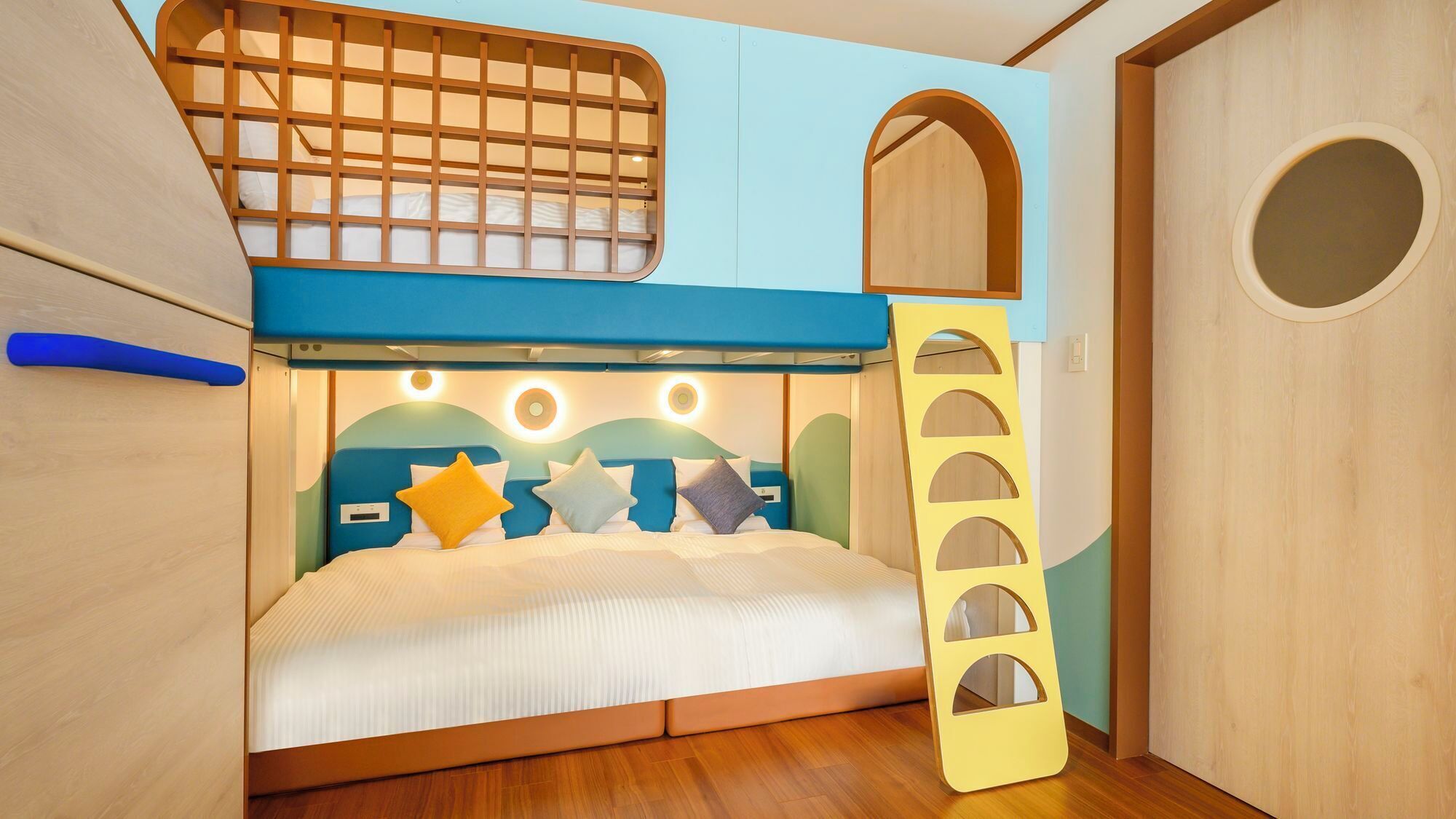 Ein Stockbett mit einer Leiter, einem kleinen Rundfenster und einer Holztür.