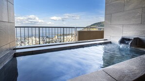 A spa area with a hot tub and a view of the cityscape. - Kamenoi Hotel Atami (Atami)