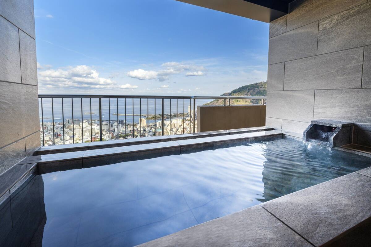 Een wellnessruimte met een jacuzzi en uitzicht op de skyline.