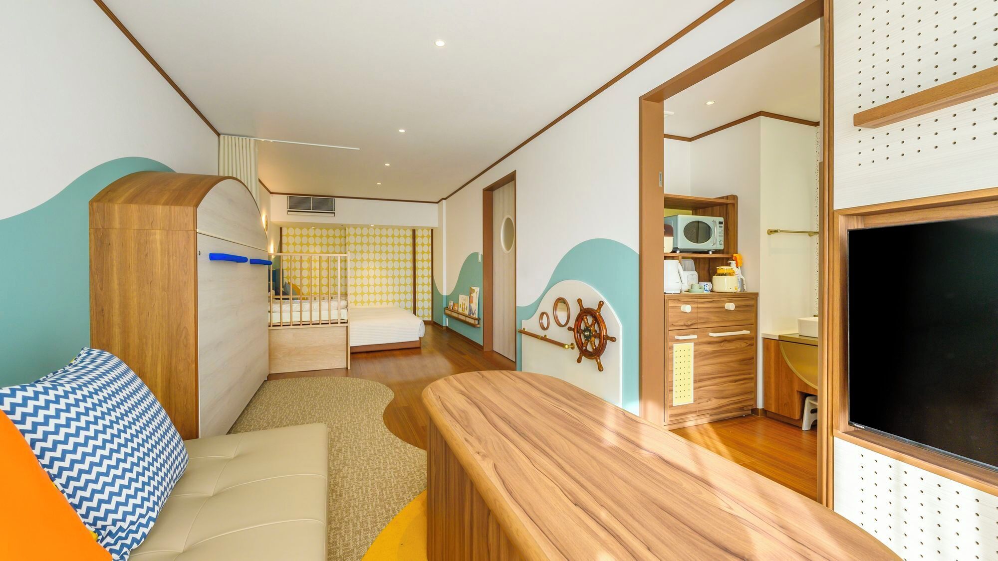 Ein kleines Zimmer mit Bett, Schreibtisch, Stuhl, Kleiderschrank und Fernseher.