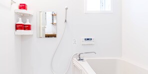 A bathroom with a bathtub, a shower, and a mirror. There are shelves with toiletries and a digital water temperature display. - Rakuten STAY HOUSE × WILL STYLE Takasaki (Takasaki)