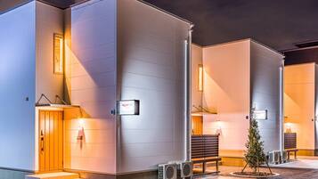 A modern hotel with a clean, minimalist design, featuring large windows and a well-lit entrance.