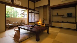 Ein traditioneller japanischer Raum mit Tatami-Boden, einem niedrigen Tisch und einer Schiebetür.
