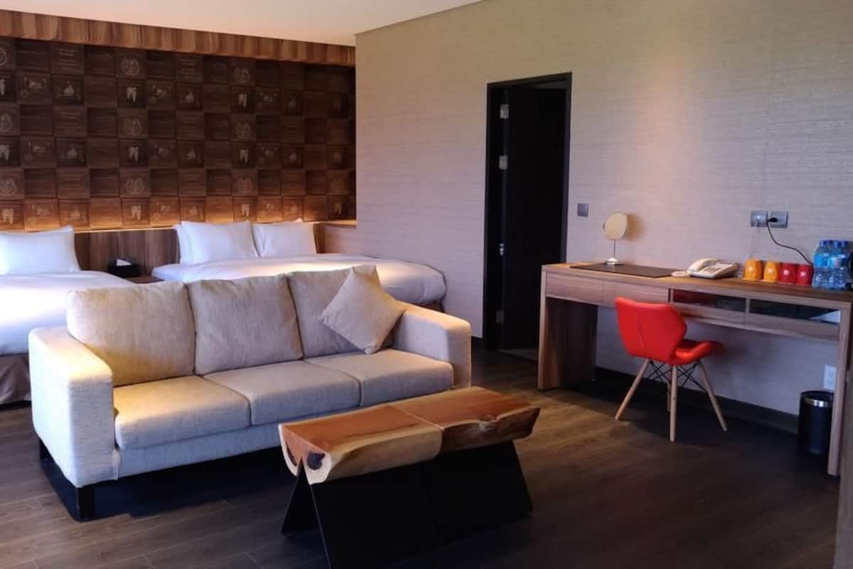 Una habitación de hotel con cama, sofá, escritorio y silla.
