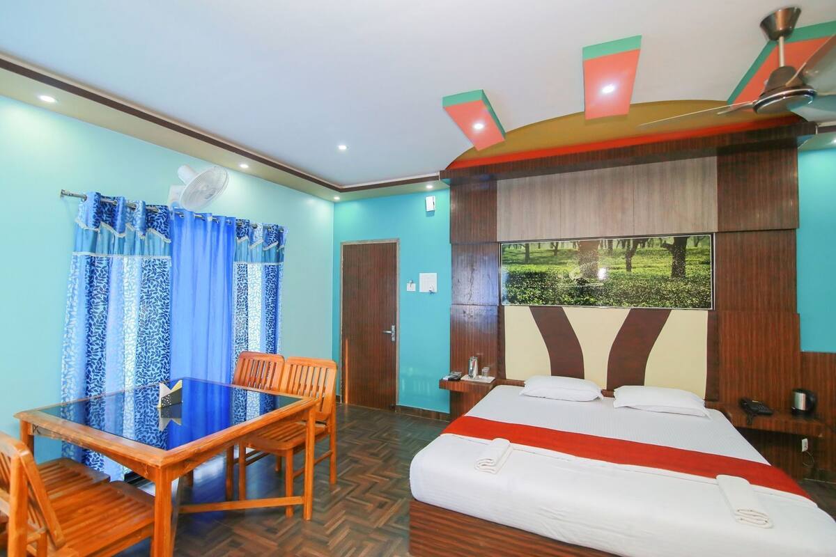 Quarto de hotel com cama, escrivaninha e cadeira.