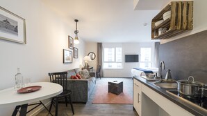 Una cocina moderna con comedor, un sofá y una pequeña mesa.