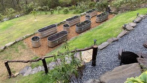 Ein Garten mit erhöhten Pflanzkästen und einem Kiesweg.
