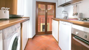 A compact kitchen with a washing machine, a sink, and a stove. - Fiorentini Charme - My Extra Home (Rome)
