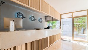 Een receptie met een houten balie, een Apple logo aan de muur en decoratieve, ronde wandkunst.