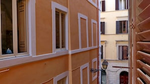 A narrow alleyway between buildings with a wooden door on the right. - Casa Navona - My Extra Home (Rome)