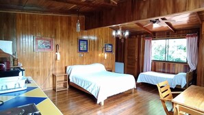 Una cabaña de madera con dos camas, una mesa de comedor y un ventilador de techo.