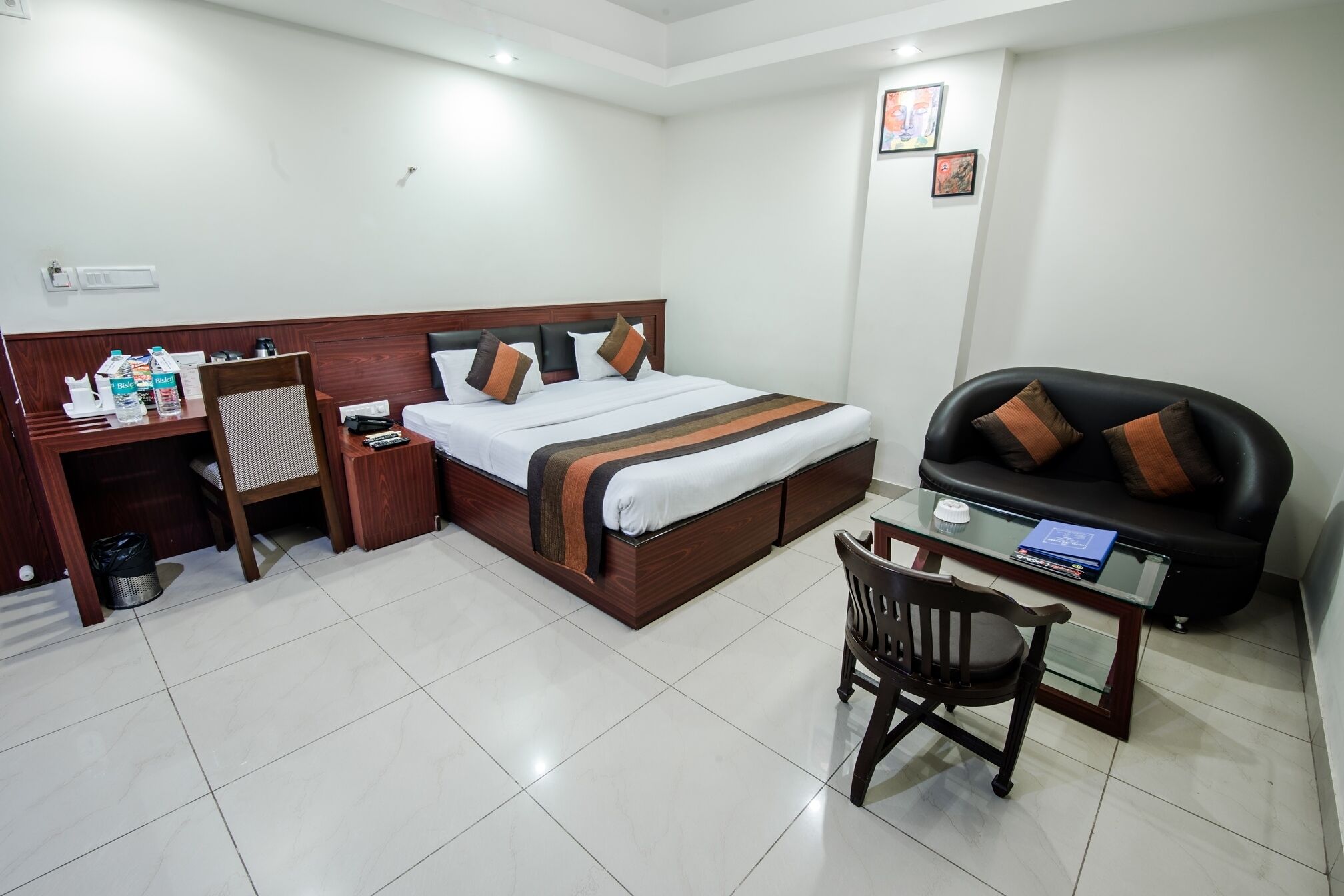 Una habitación de hotel con una cama, un escritorio con una silla, un sofá y una mesita.