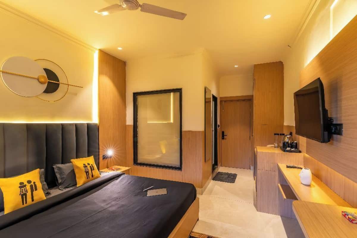 Une chambre d’hôtel moderne équipée d’un grand lit, d’un bureau, d’une télévision et d’un ventilateur de plafond.