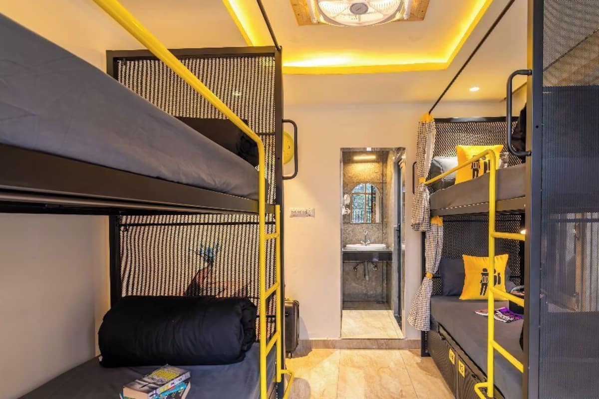 Une chambre compacte avec des lits superposés, un petit bureau et une fenêtre donnant sur un paysage agréable.
