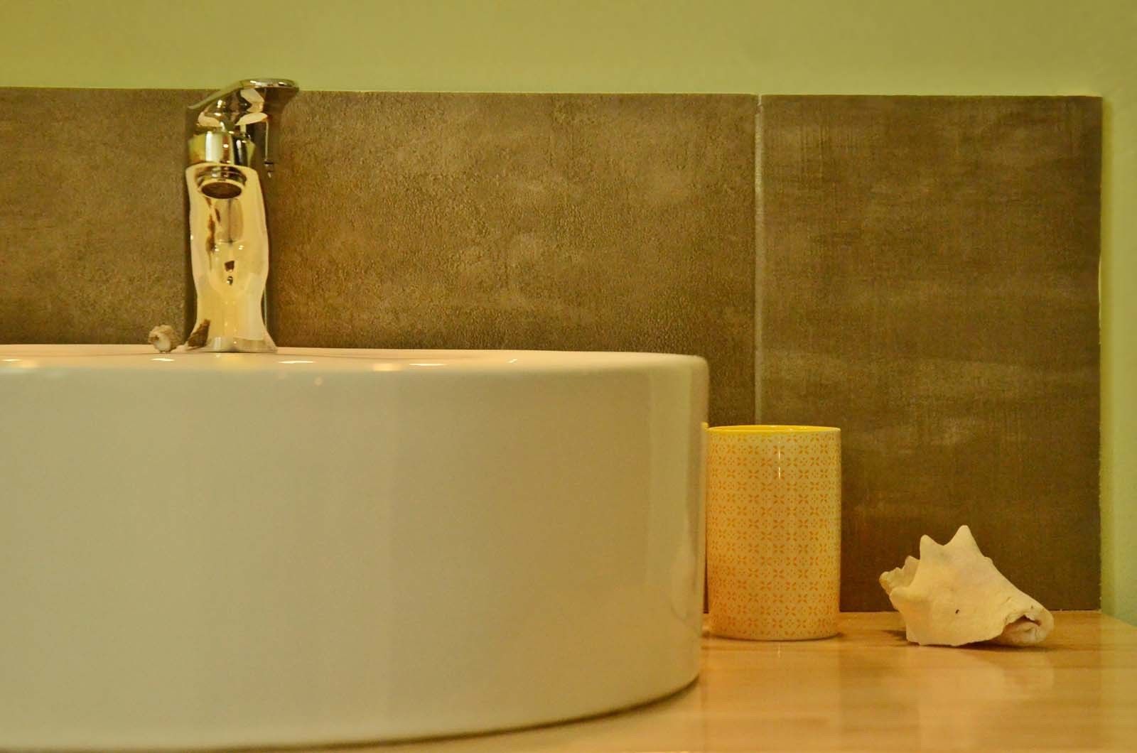 A bathroom sink with a faucet, a toilet paper roll, and a seashell on the counter.