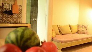 A room with a bed, a tiled wall, and a kitchen area with utensils. - Circle Inn (Athens)