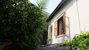 A narrow pathway leading to a white building with a wooden window frame. - Moon House Nha Trang (Nha Trang)