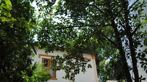 A building with a white facade, a wooden window frame, and a balcony with a railing. - Moon House Nha Trang (Nha Trang)
