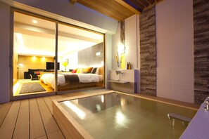 A modern bedroom with a glass door leading to a bathroom, a wooden deck, and a spa area. - Bansyoukaku Shikishima (Ureshino)