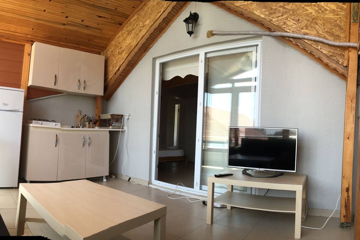 Una cucina compatta con frigorifero, pensili e un'area pranzo con tavolo.