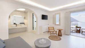 Een moderne hotelkamer met een ruime boogvormige deuropening naar een badkamer, een flatscreen televisie aan de muur en een balkon met zitplaatsen buiten.