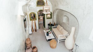 Een interieur met een bank, een hanglamp en een grote vaas.