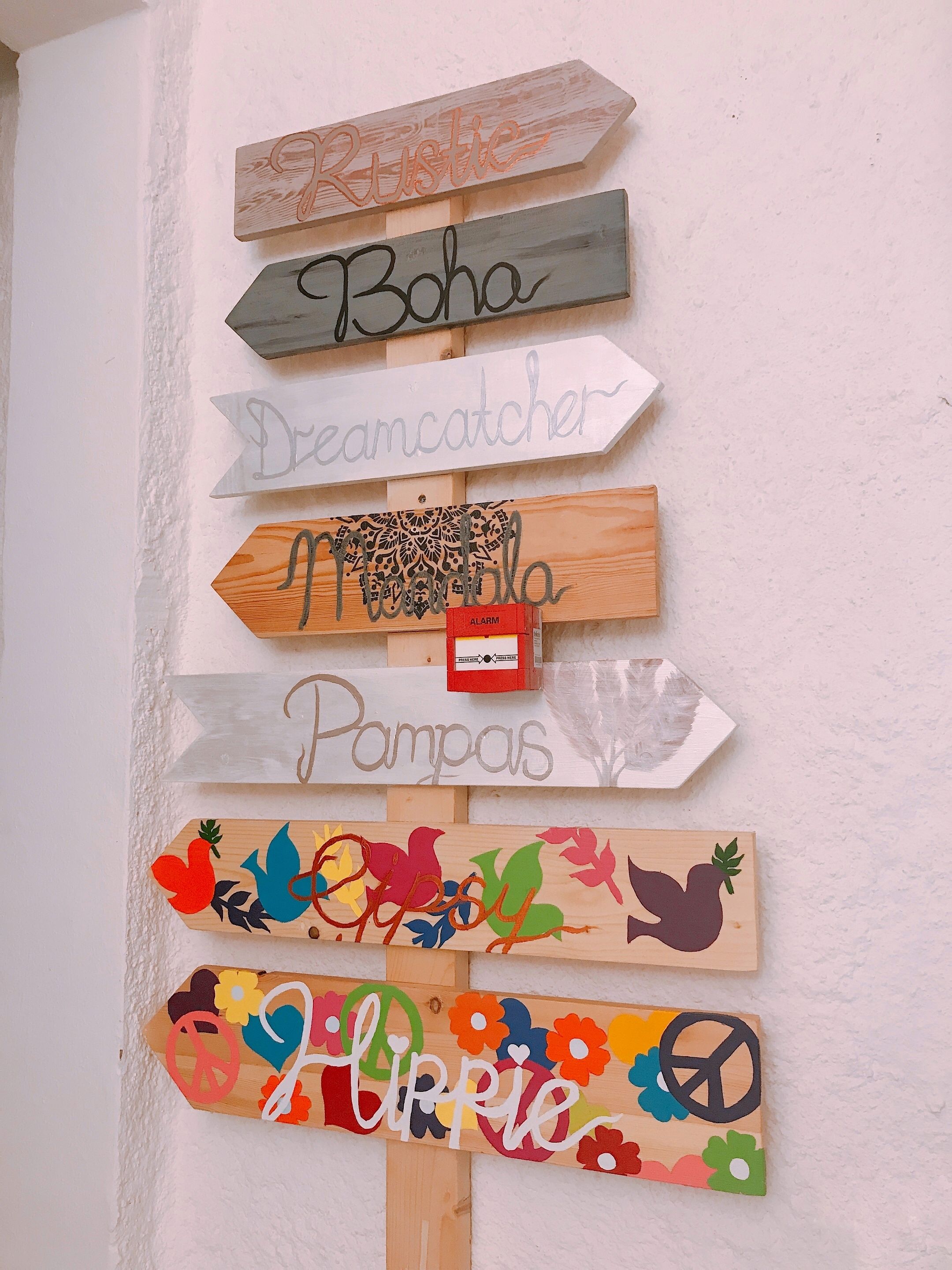 A wall with various wooden signs, each with different text and designs.