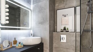 Un bagno moderno con uno specchio grande, un lavandino e una doccia.