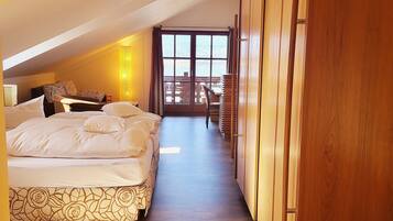 Ein Hotelzimmer mit einem großen Bett, einem Schreibtisch und Blick ins Freie.