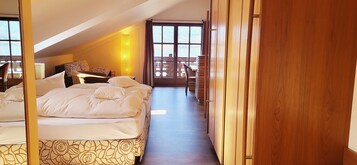 Habitación de hotel con una cama grande, un escritorio y vistas al exterior.