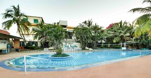 A swimming pool with a tiled deck, surrounded by palm trees and a sign that reads "Sai leela". - Hotel Sai Leela (Rahata)