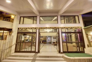 A hotel entrance with a double door, a staircase leading up, and a view into the interior. - Hotel Sai Leela (Rahata)