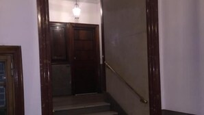 A staircase with wooden railings and a handrail, leading to a door at the top. - La Capitale B&B (Rome)