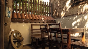 Un espace extérieur aménagé dans un style rustique, avec des chaises et une table en bois, une clôture en bois et un panneau indiquant que l’on se trouve en Australie.