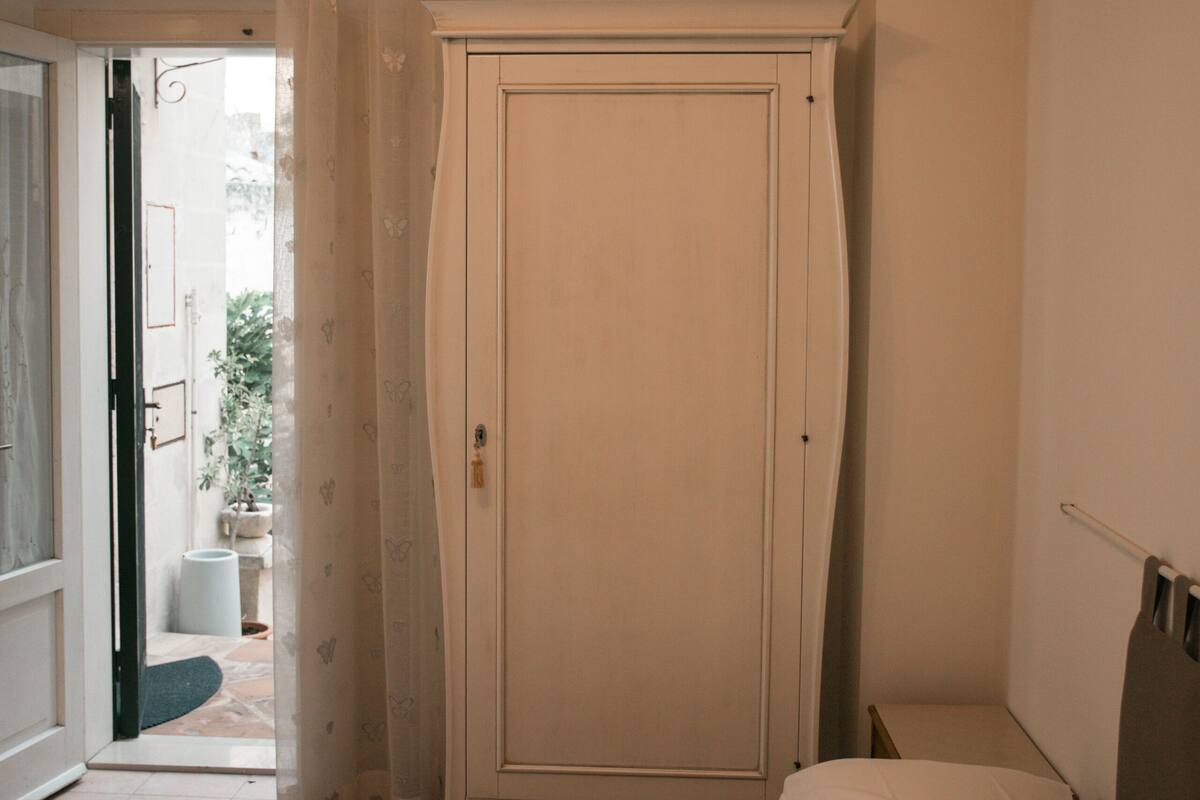 Un dormitorio con cama, una puerta y vistas al exterior.
