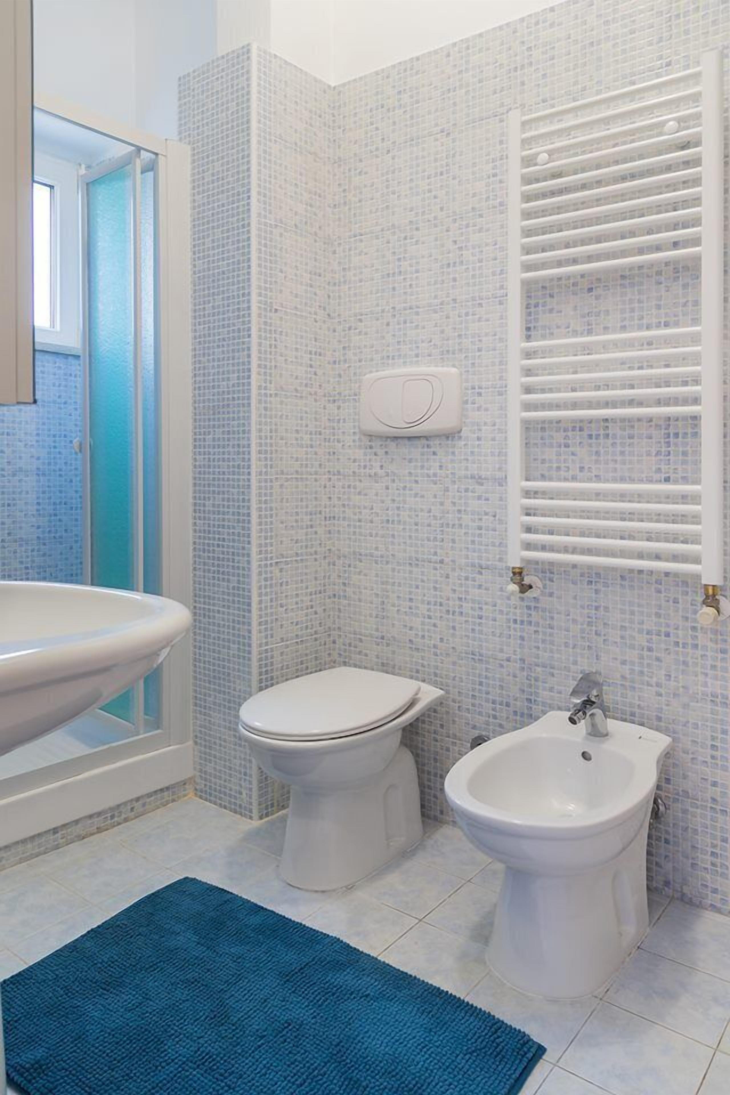 A bathroom with a large bathtub, a toilet, and a bidet.