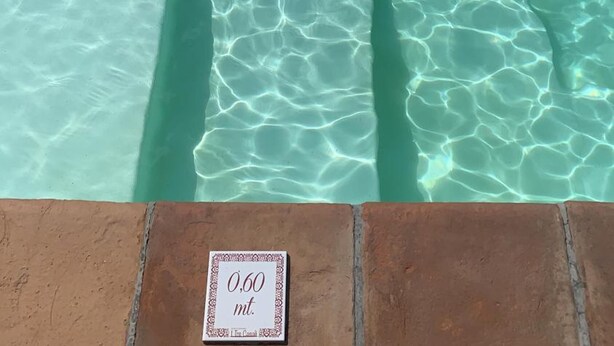 A clear pool with visible water clarity and a depth marker of 0.60 meters. - Azienda Agrituristica I Tre Casali (Magione)