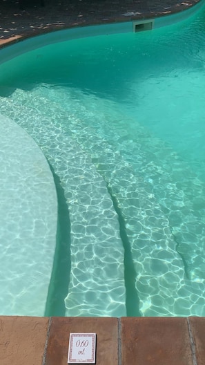 Ein klares Schwimmbecken mit guter Sichtbarkeit und einer Tiefenmarkierung von 0,60 Metern.
