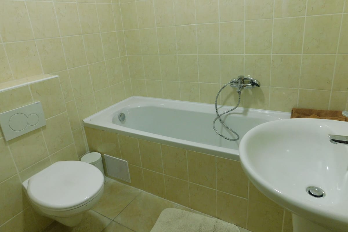 Un baño con bañera, inodoro y lavamanos.
